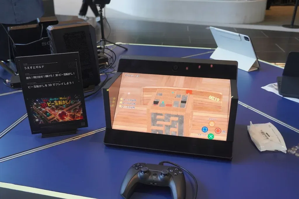 空間再現ディスプレイに表示された3Dビー玉転がしと、手前に置かれたゲームパッド